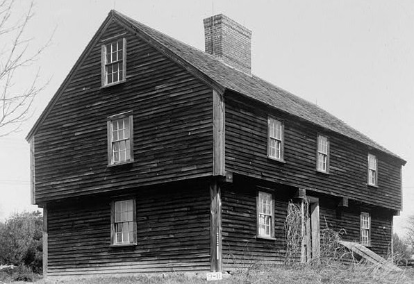 A mid-century Garrison Colonial with overhanging second story