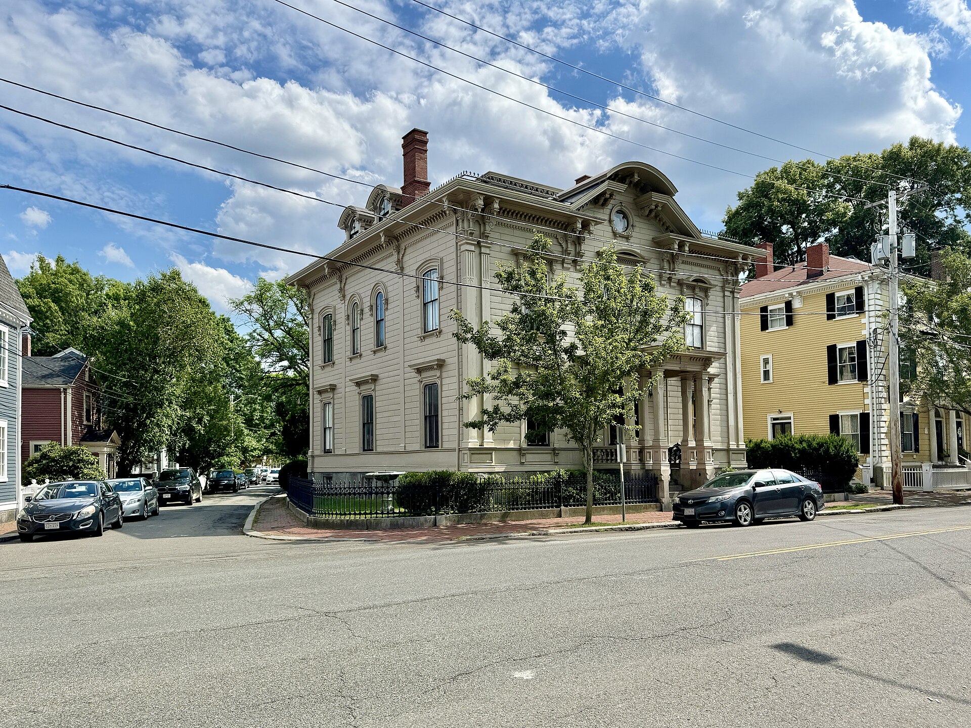 Paired wooden brackets under deep eaves define the Italianate